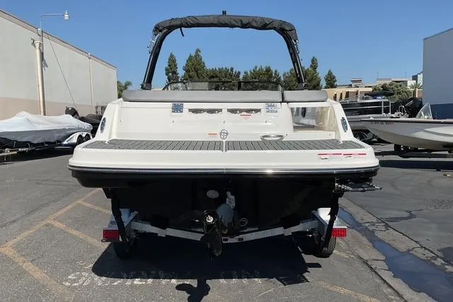 Slide: The Image of 2025 Bayliner VR6 Bowrider I/O boat, rear view, parked outdoors on a sunny day. - 2