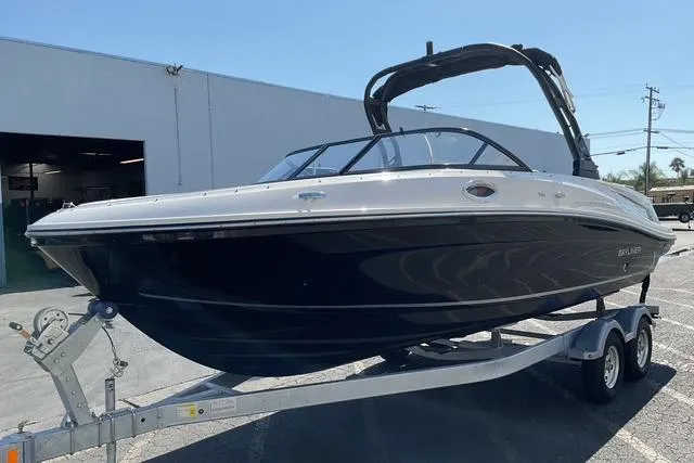 Slide: The Image of 2025 Bayliner VR6 Bowrider I/O on trailer, parked outdoors near a building. - 5