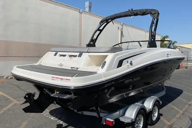 Slide: The Image of 2025 Bayliner VR6 Bowrider I/O boat on trailer, parked outdoors. - 6