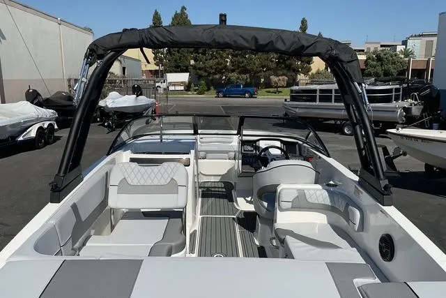 Slide: The Image of 2025 Bayliner VR6 Bowrider I/O with spacious seating and sleek design in a marina setting. - 7
