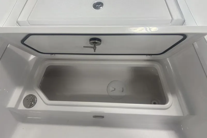 Slide: The Image of 2026 Sportsman Masters 227 boat storage compartment with open lid and secure lock. - 10