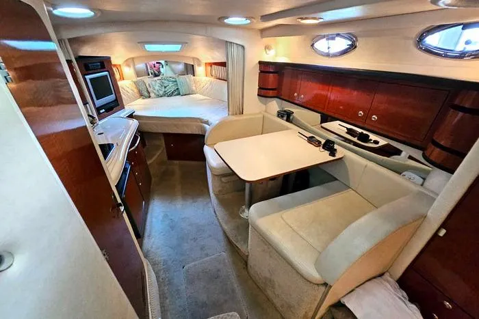Slide: The Image of 2004 Sea Ray 300 Sundancer cabin interior with cozy seating, dining area, and sleeping quarters. - 14