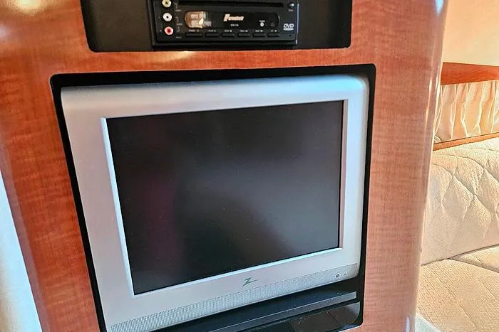 Slide: The Image of 2004 Sea Ray 300 Sundancer interior with built-in TV and DVD player. - 17