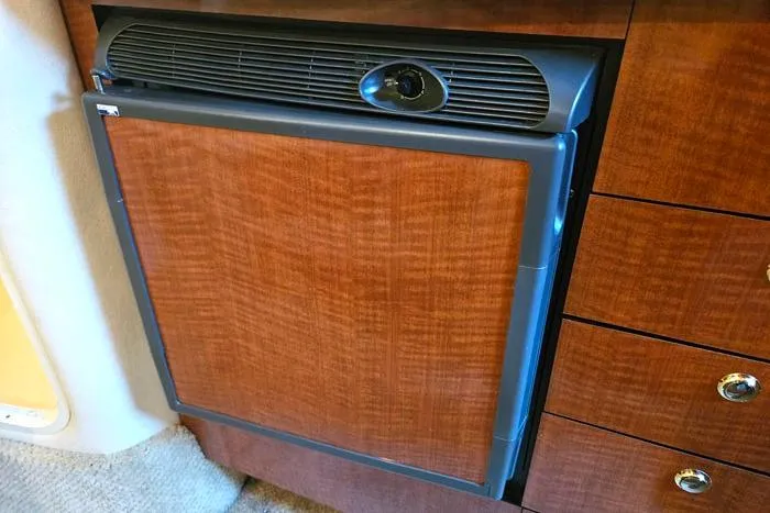 Slide: The Image of 2004 Sea Ray 300 Sundancer cabin refrigerator with wood paneling and sleek design. - 18