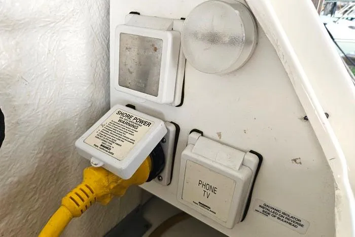 Slide: The Image of 2004 Sea Ray 300 Sundancer shore power and phone/TV connection panel. - 26