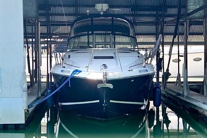 Slide: The Image of 2004 Sea Ray 300 Sundancer docked in a covered marina slip. - 29