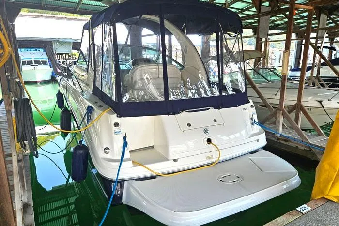 Slide: The Image of 2004 Sea Ray 300 Sundancer docked in a covered marina, rear view. - 3
