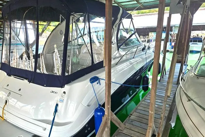 Slide: The Image of 2004 Sea Ray 300 Sundancer docked in a covered marina, side view. - 4