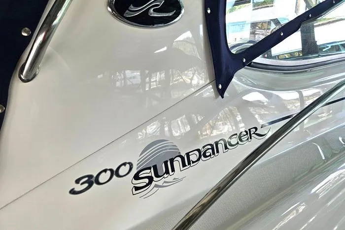 Slide: The Image of 2004 Sea Ray 300 Sundancer boat exterior with logo and window detail. - 5