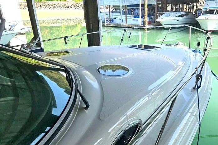 Slide: The Image of 2004 Sea Ray 300 Sundancer docked in a marina, showcasing sleek design and polished surface. - 6