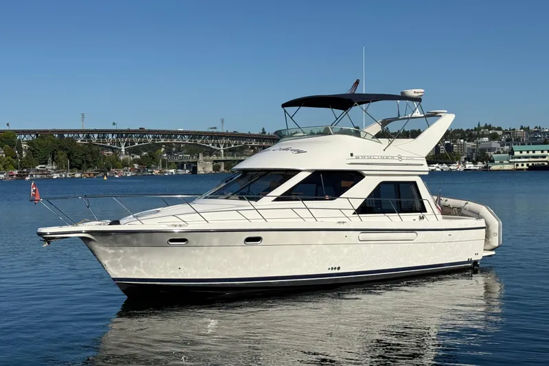 Slide: The Image of 1999 Bayliner 3788 Command Bridge Motoryacht on calm water, clear sky background. - 12
