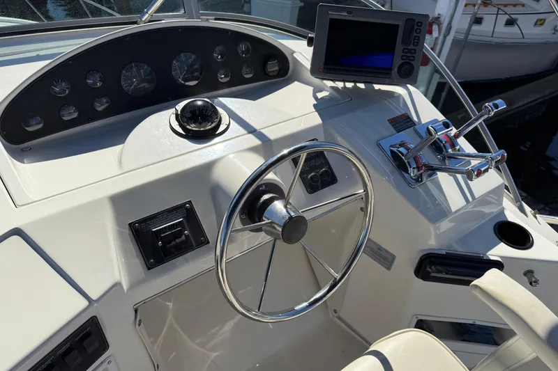 Slide: The Image of 1999 Bayliner 3788 Command Bridge Motoryacht helm with steering wheel and navigation controls. - 13