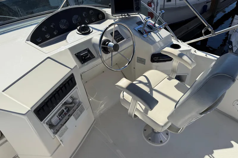 Slide: The Image of 1999 Bayliner 3788 Command Bridge Motoryacht helm with steering wheel and control panel. - 14