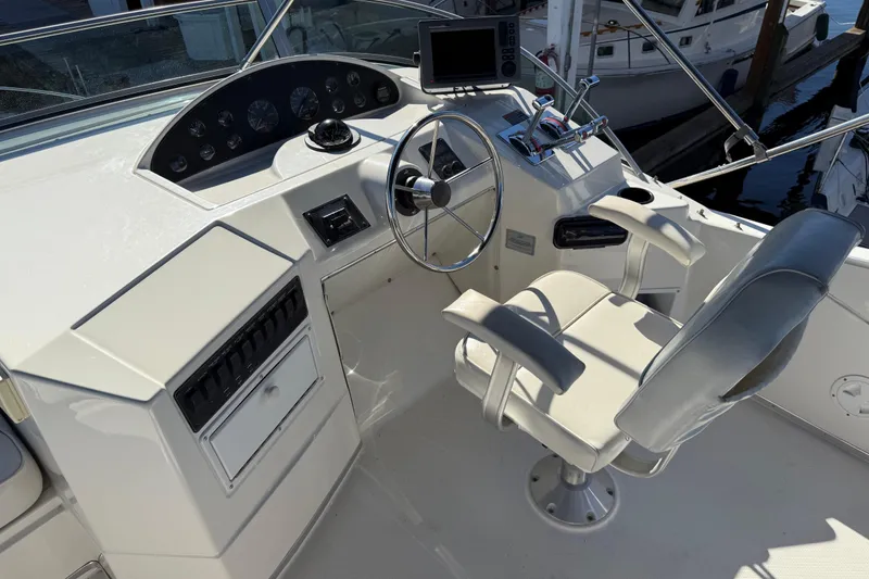 Slide: The Image of 1999 Bayliner 3788 Command Bridge Motoryacht helm with steering wheel and control panel. - 15
