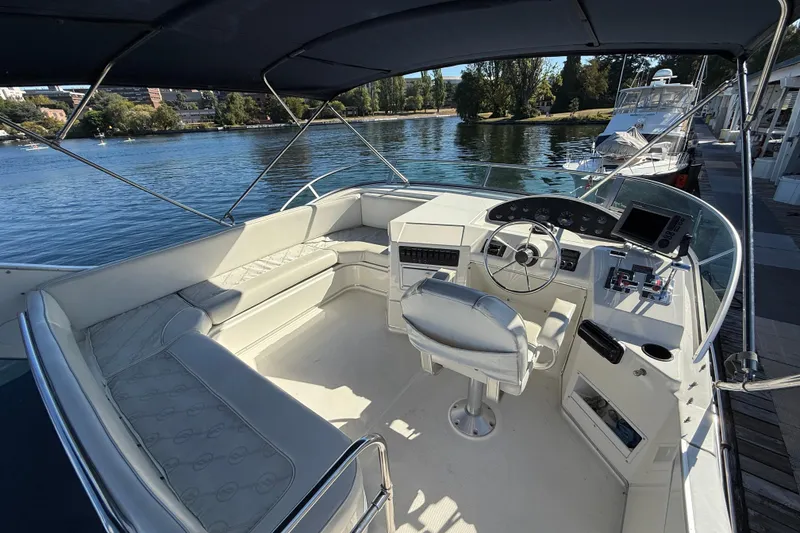 Slide: The Image of 1999 Bayliner 3788 Command Bridge Motoryacht interior with helm, seating, and water view. - 16