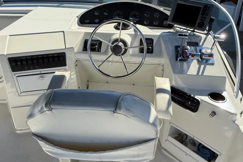 Slide: The Image of 1999 Bayliner 3788 Command Bridge Motoryacht helm with steering wheel and navigation controls. - 18