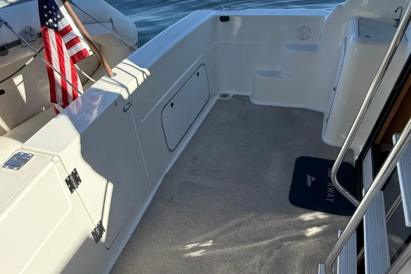 Slide: The Image of 1999 Bayliner 3788 Command Bridge Motoryacht deck with American flag and steps. - 19