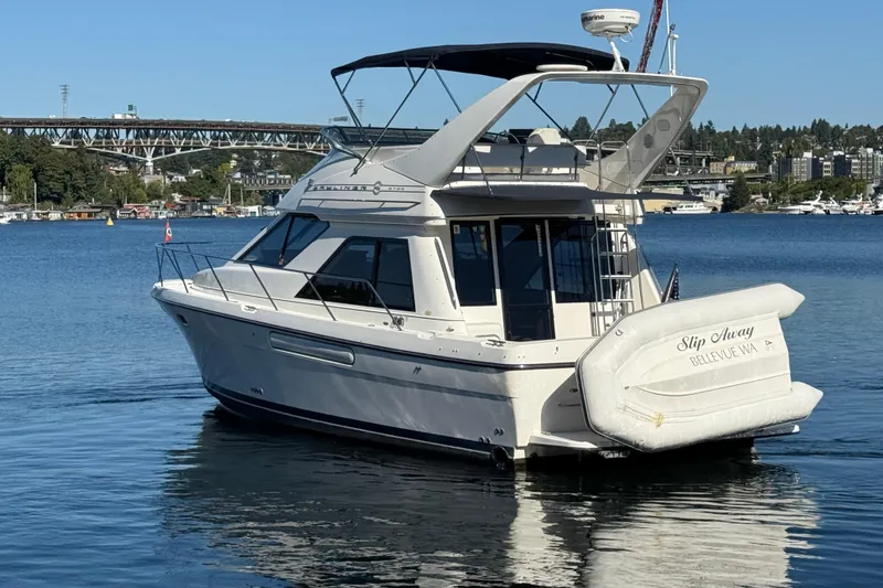 Slide: The Image of 1999 Bayliner 3788 Command Bridge Motoryacht on calm water with scenic background. - 2