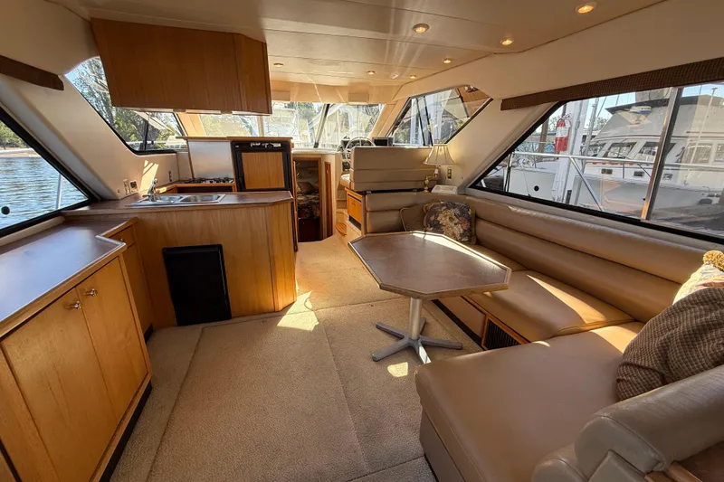 Slide: The Image of 1999 Bayliner 3788 Command Bridge Motoryacht interior with kitchen, seating area, and large windows. - 22