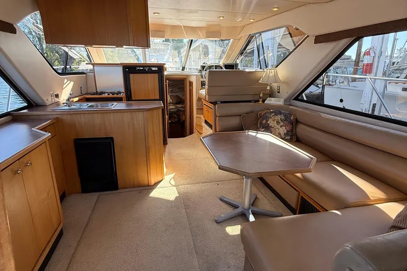 Slide: The Image of 1999 Bayliner 3788 Command Bridge Motoryacht interior with kitchen, seating, and table. - 23