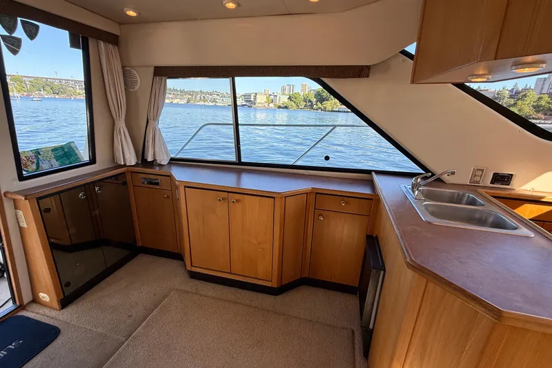 Slide: The Image of Interior of 1999 Bayliner 3788 Command Bridge Motoryacht with wooden cabinetry and waterfront view. - 26