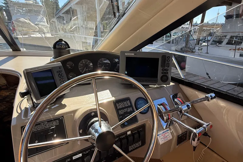 Slide: The Image of 1999 Bayliner 3788 Command Bridge Motoryacht helm with steering wheel and navigation instruments. - 32