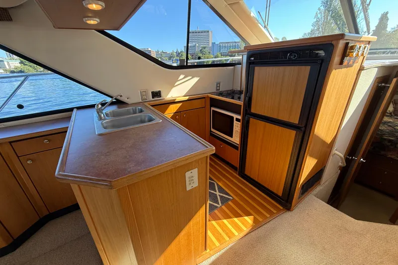 Slide: The Image of 1999 Bayliner 3788 Command Bridge Motoryacht kitchen with sink, stove, and refrigerator. - 34