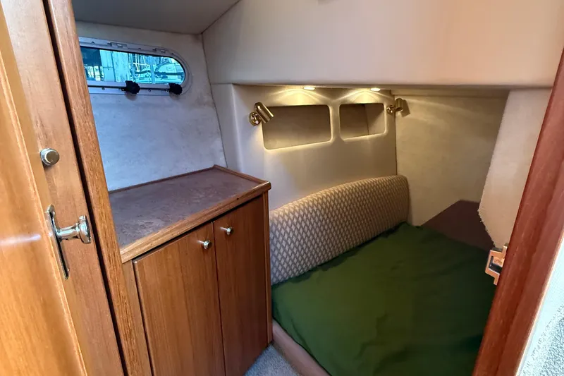 Slide: The Image of 1999 Bayliner 3788 Command Bridge Motoryacht cabin with cozy bed and wooden cabinetry. - 37