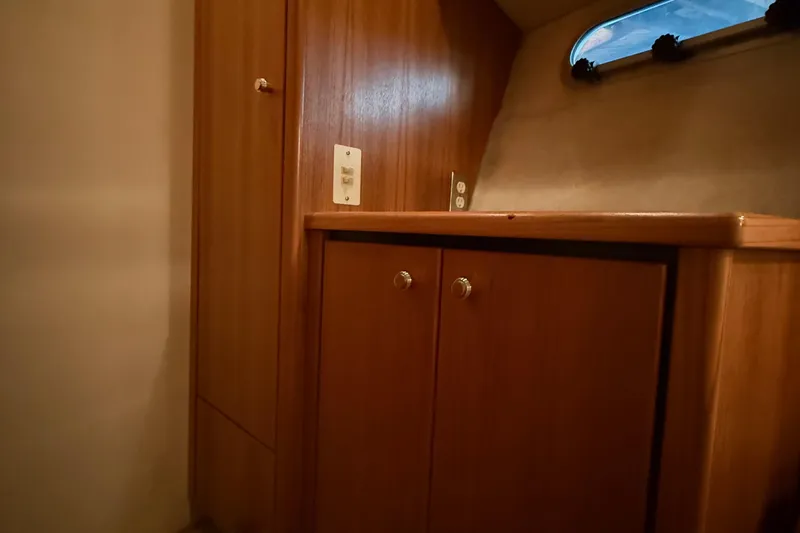 Slide: The Image of 1999 Bayliner 3788 Command Bridge Motoryacht interior with wooden cabinetry and small window. - 39