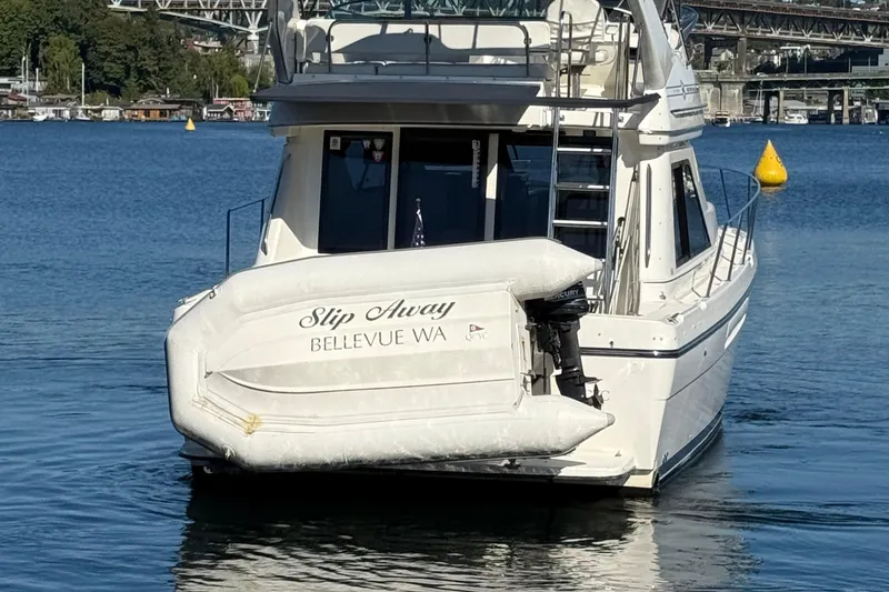 Slide: The Image of Bayliner 3788 Command Bridge Motoryacht 1999 on water, with inflatable boat attached. - 4