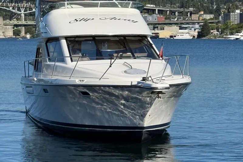 Slide: The Image of 1999 Bayliner 3788 Command Bridge Motoryacht on calm water, cityscape background. - 8