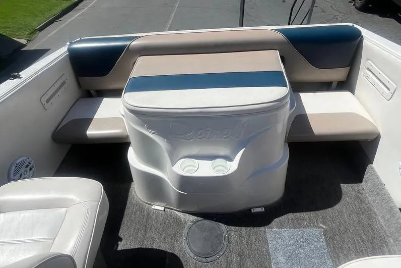Slide: The Image of 1997 Reinell 240 boat interior with cushioned seating and cup holders. - 10