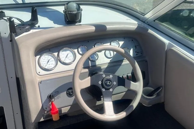 Slide: The Image of 1997 Reinell 240 boat dashboard with steering wheel and instrument gauges. - 12