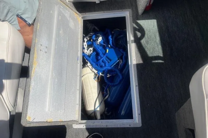 Slide: The Image of Storage compartment on a 1997 Reinell 240 boat with blue ropes and equipment. - 17
