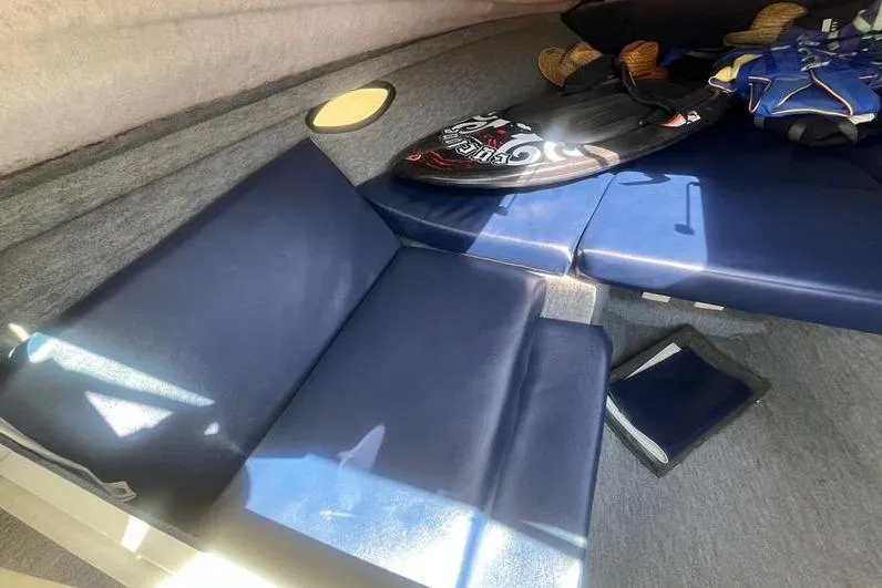 Slide: The Image of Interior of a 1997 Reinell 240 boat with blue seating and wakeboard. - 20
