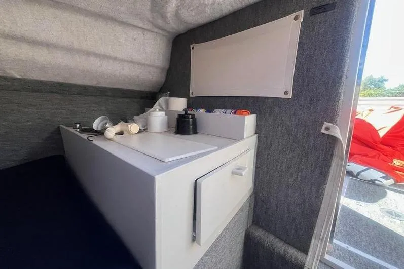 Slide: The Image of 1997 Reinell 240 boat interior with compact kitchenette and storage. - 21