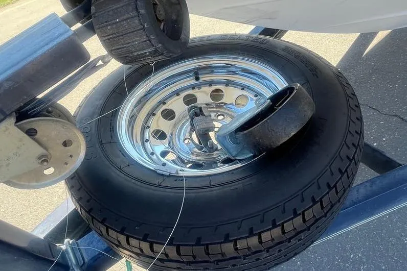 Slide: The Image of Trailer wheel with lock on a 1997 Reinell 240 boat trailer. - 27