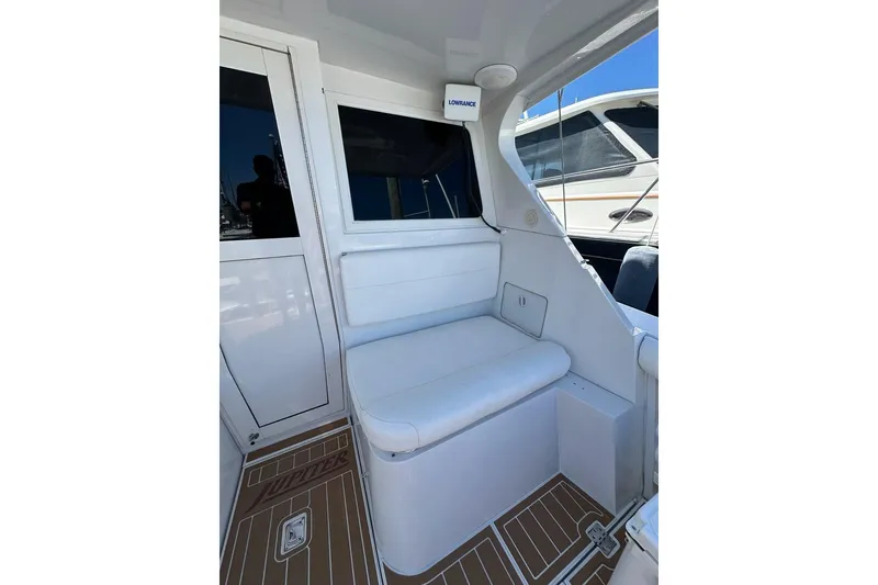 Slide: The Image of 2001 Jupiter 35 Convertible boat interior with white seating and wood-patterned flooring. - 12