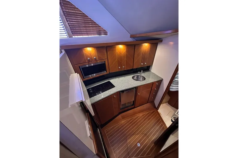 Slide: The Image of Luxurious 2001 Jupiter 35 Convertible yacht kitchen with wood cabinets and modern appliances. - 17