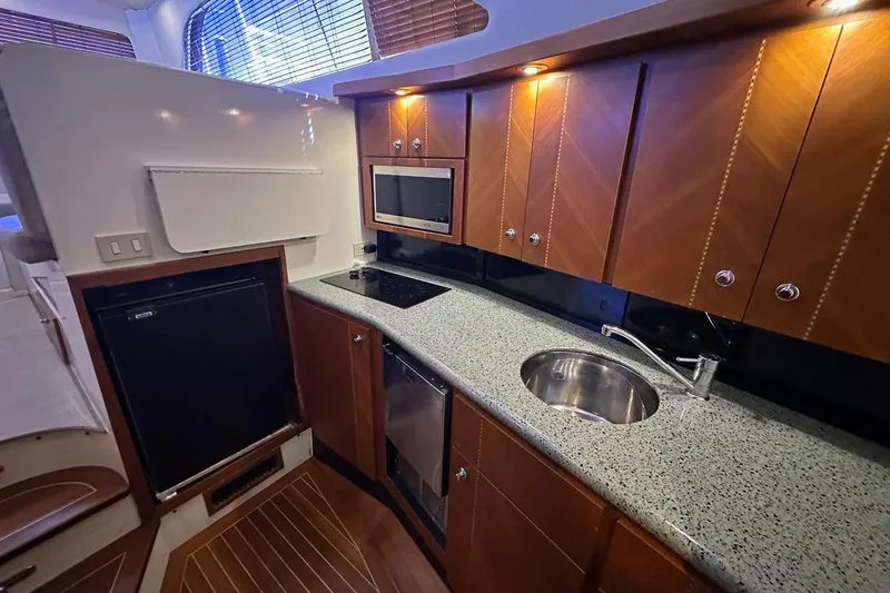 Slide: The Image of Luxurious kitchen in 2001 Jupiter 35 Convertible yacht with wood cabinets and modern appliances. - 18