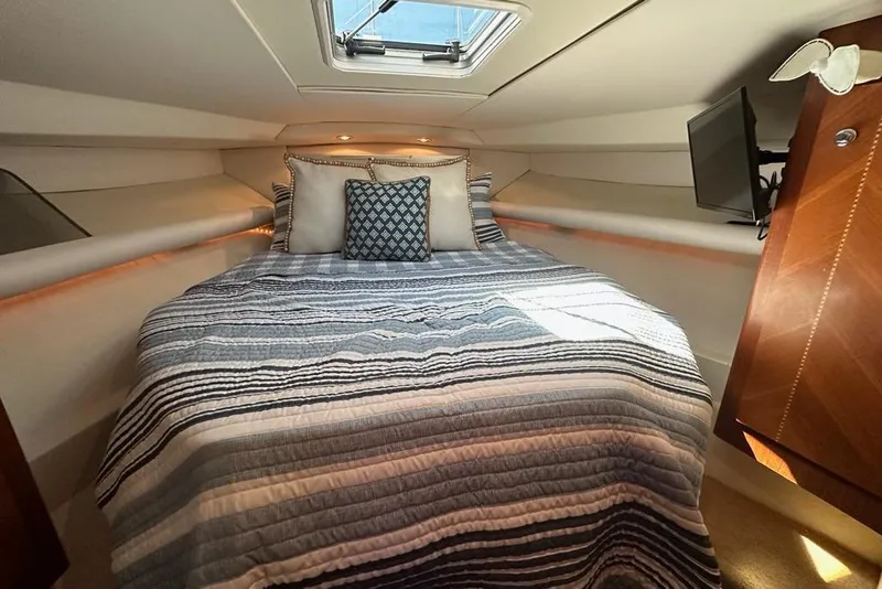 Slide: The Image of Cozy cabin interior of 2001 Jupiter 35 Convertible with striped bedding and pillows. - 21