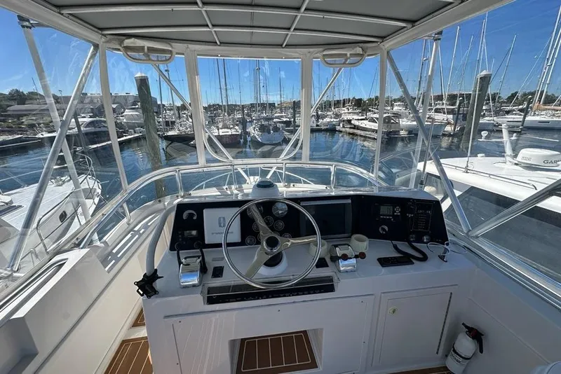 Slide: The Image of Helm of 2001 Jupiter 35 Convertible yacht in marina, showcasing steering and controls. - 35