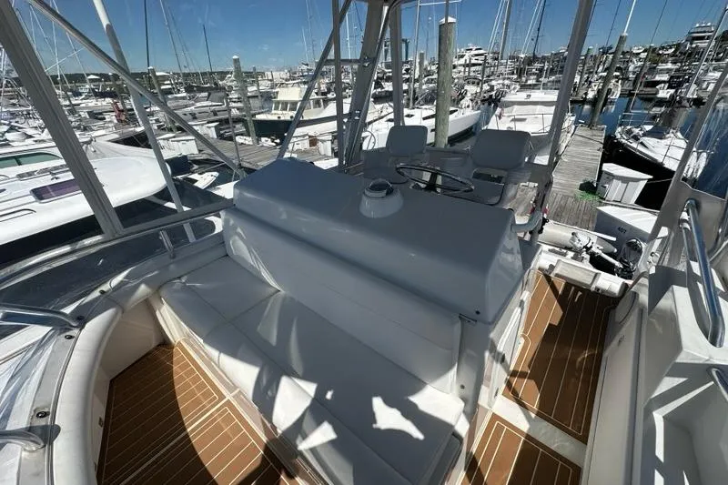 Slide: The Image of Interior view of 2001 Jupiter 35 Convertible yacht at marina, showcasing seating and helm. - 37