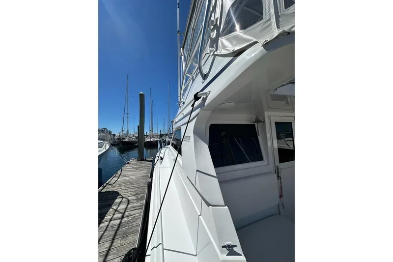 Slide: The Image of 2001 Jupiter 35 Convertible yacht docked at marina under clear blue sky. - 4