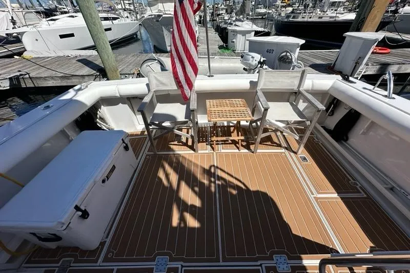 Slide: The Image of 2001 Jupiter 35 Convertible boat deck with chairs, table, and American flag at marina. - 40