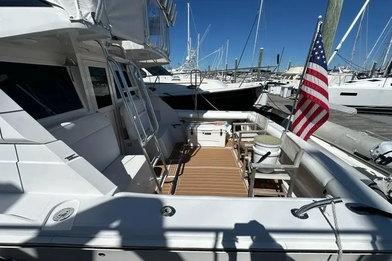 Slide: The Image of 2001 Jupiter 35 Convertible yacht with American flag, docked at marina. - 6