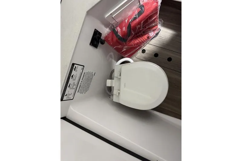 Slide: The Image of 2026 Sportsman Heritage 321 Center Console boat interior with toilet and safety equipment. - 37
