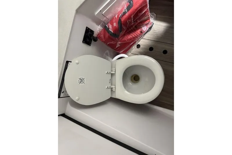 Slide: The Image of Toilet on 2026 Sportsman Heritage 321 Center Console boat, with red life jacket nearby. - 61