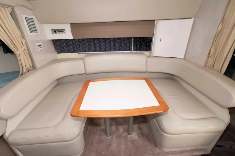 Slide: The Image of 2002 Formula 31 Performance Cruiser interior with beige leather seating and wooden table. - 10