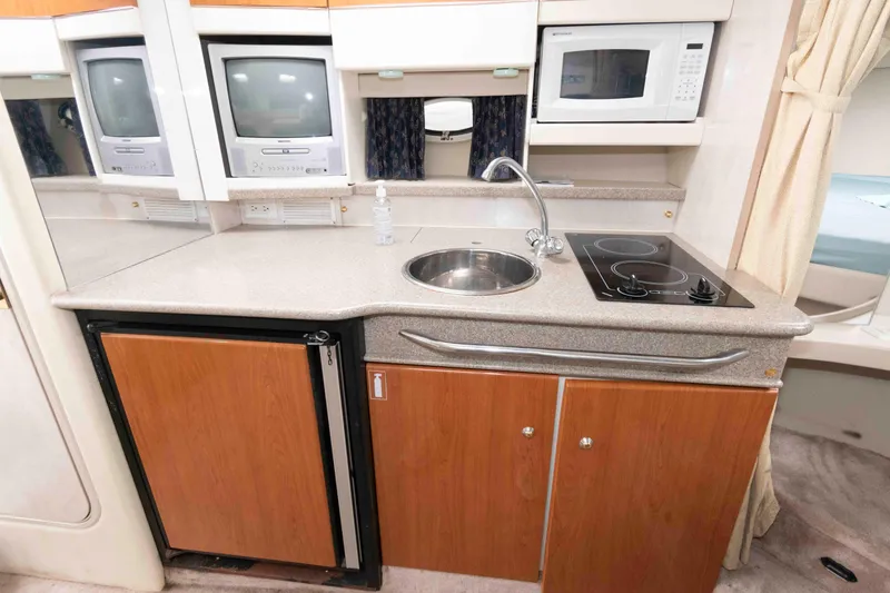 Slide: The Image of 2002 Formula 31 Performance Cruiser kitchen with sink, stove, microwave, and TV. - 11